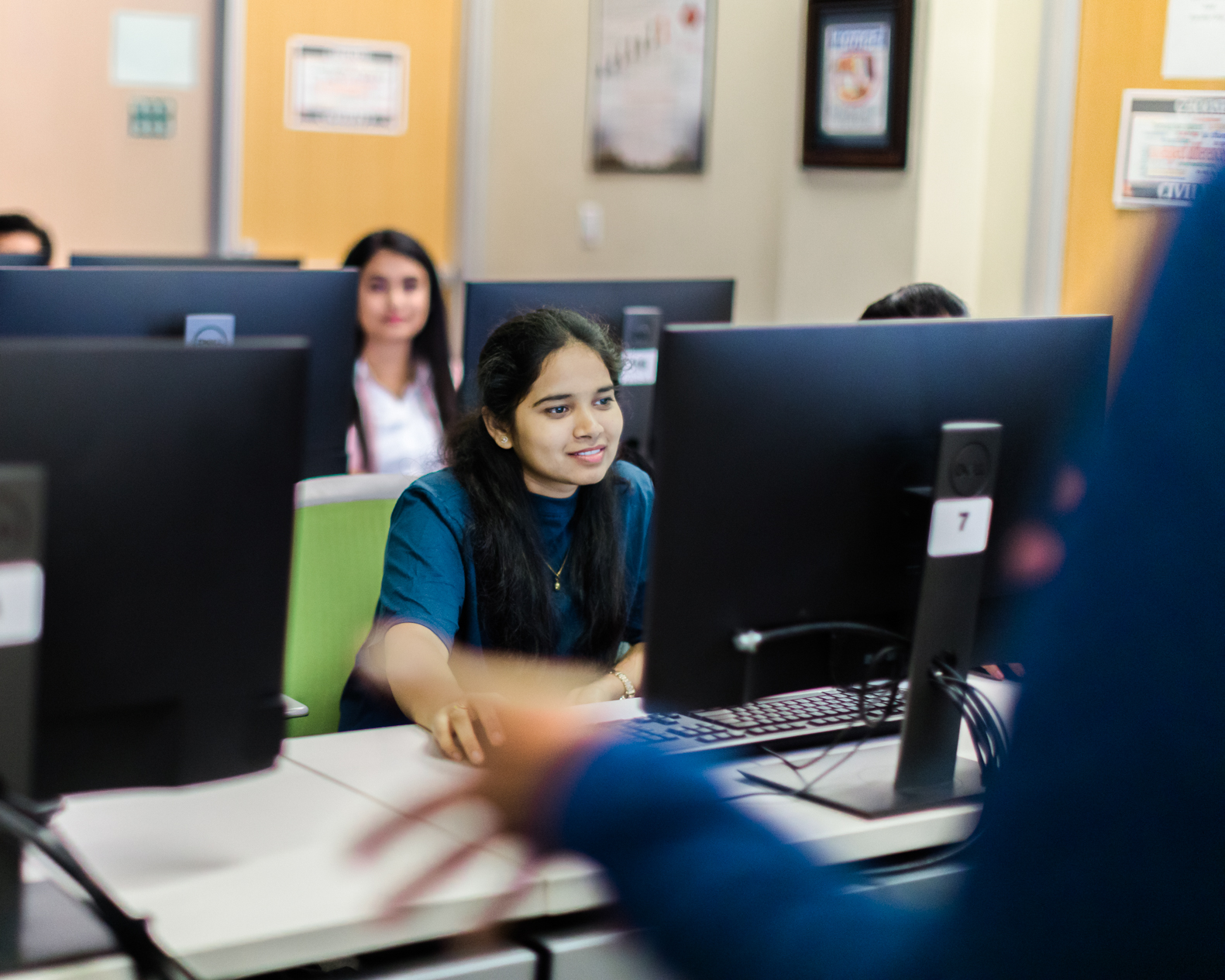 Woman working on desktop smiling during a lecture